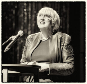 SW Foto Claudia Roth am Rednerpult, bei der 75 Jahr-Feier für Rio Reiser in der Berliner Volksbühne Januar 2025, Foto: Sabine Drwenzki, John Colton